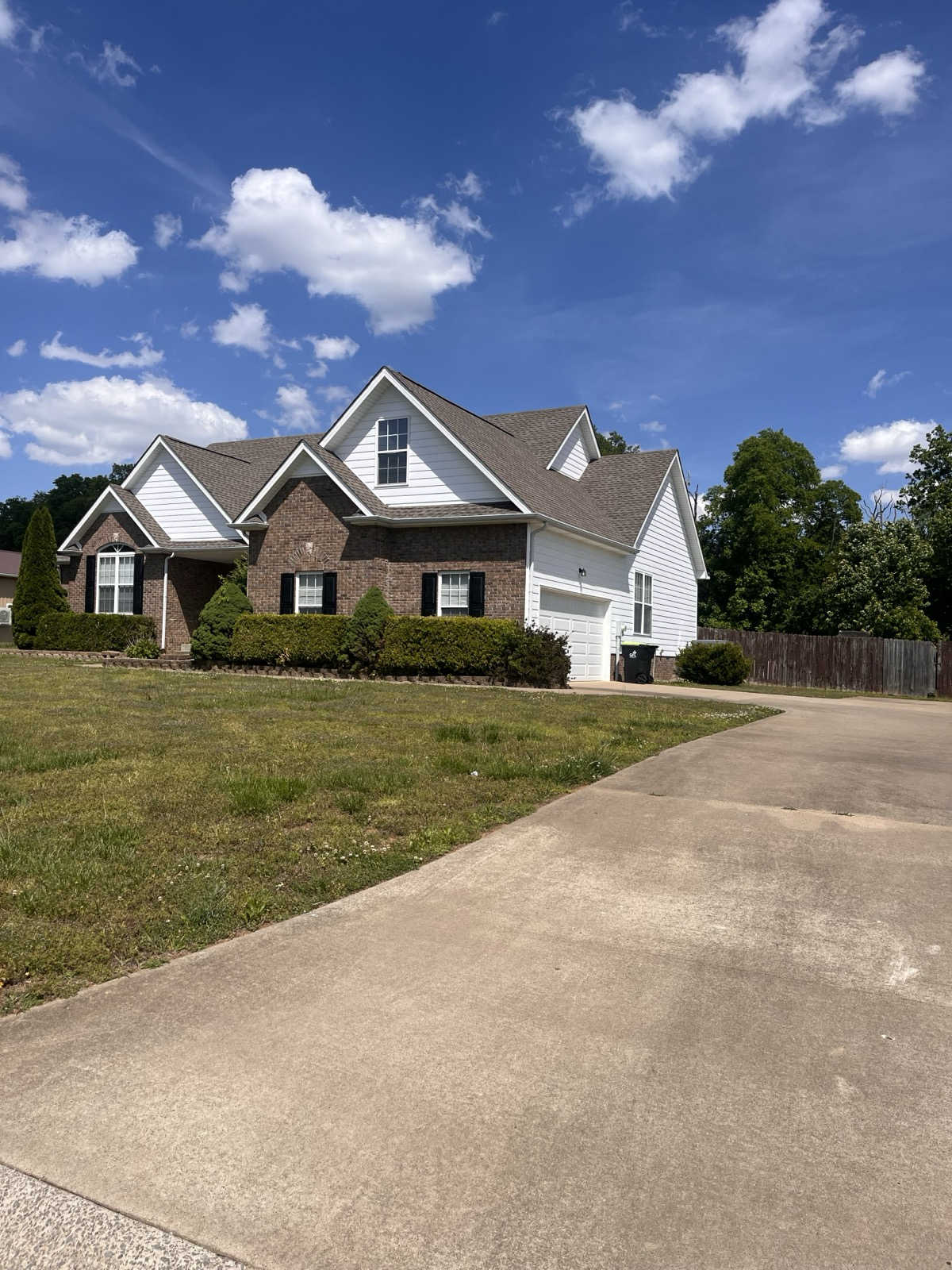 Brick home with white vinyl siding gables and garage wall installed by AmeriSide Exteriors